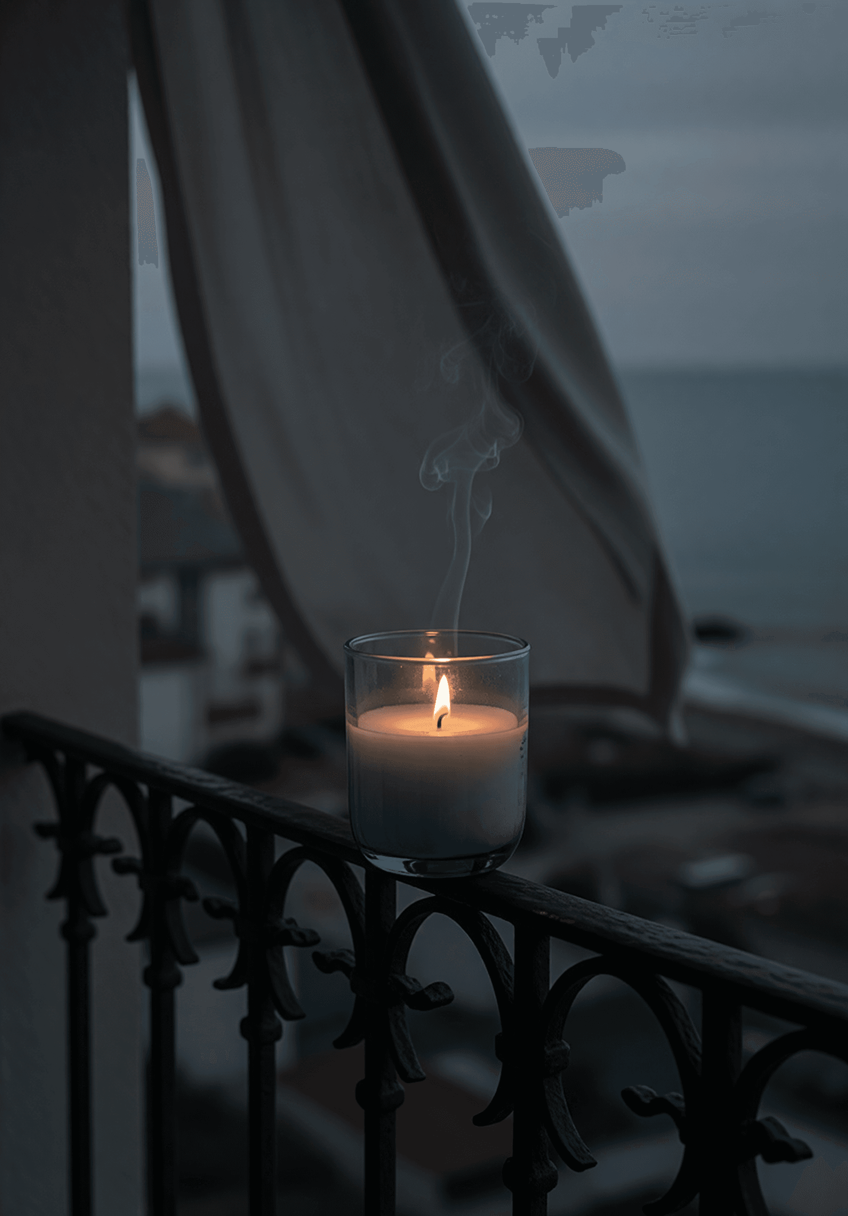 Hôtel Bleu — a lit candle in pale-blue glass on an iron railing.